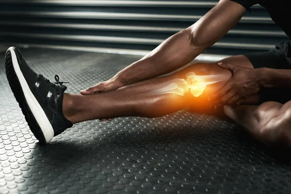 Em caso de dúvida, estique-a. Estúdio tiro de um homem irreconhecível examinando uma lesão no joelho durante o treino. — Fotografia de Stock
