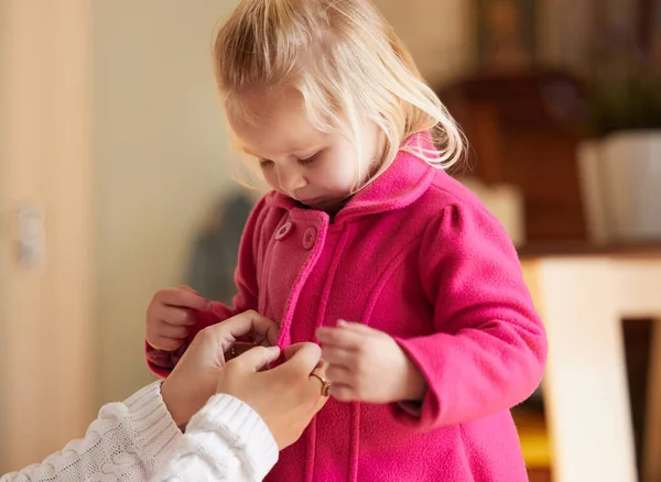 Dobbiamo fare scorta di biscotti e latte. Girato di una donna abbottonando le sue figlie cappotto rosa. — Foto Stock