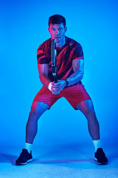 Listo para conquistar la corte. Foto filtrada azul de un hombre posando con una raqueta de tenis en el estudio. — Foto de Stock