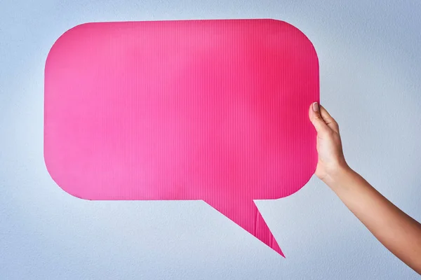 Voice out your opinions. Shot of an unrecognizable woman holding up a speech bubble against a blue background.