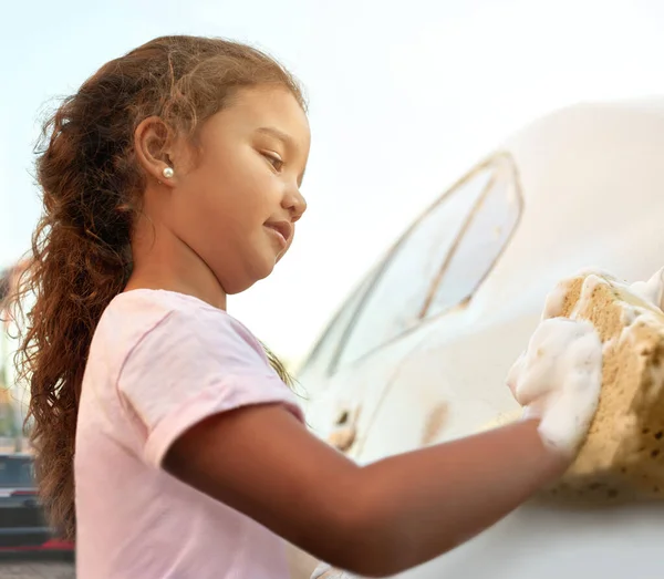 Comienzan las tareas desde la primera infancia. Un disparo de una joven lavando un coche afuera. — Foto de Stock