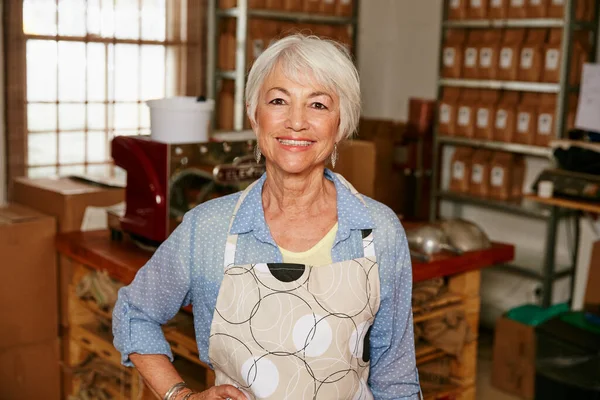 Orgulloso de mi cafetería. Retrato recortado de una mujer mayor de pie con la mano en la cadera en un asador. — Foto de Stock