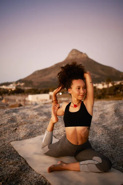 Le apasiona el yoga. Largura completa de una atractiva joven practicando yoga en la playa al atardecer. —  Fotos de Stock