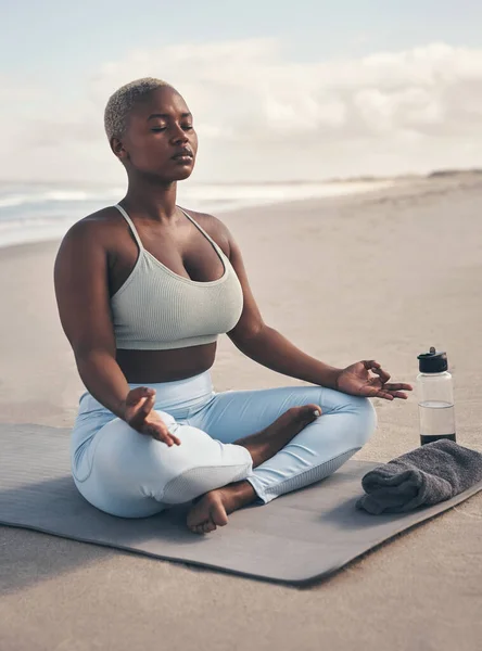 Yoga hielp me een thuis in mezelf te vinden. Shot van een vrouw mediteren tijdens haar yoga routine op het strand. — Stockfoto
