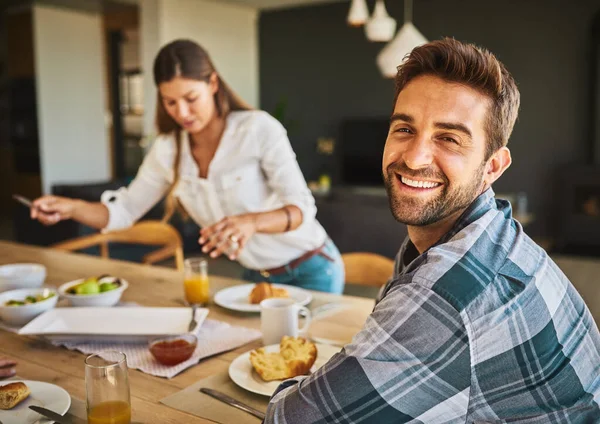 We delen elke maaltijd samen. Portret van een man ontbijten met zijn vrouw op de achtergrond. — Stockfoto