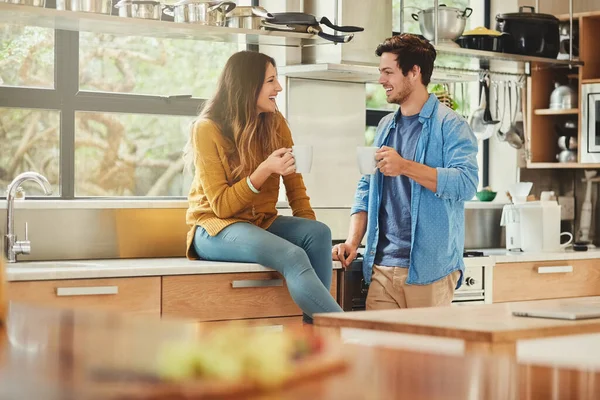 Догоняю на кухне. Снимок любящей молодой пары, беседующей на кухне. — стоковое фото