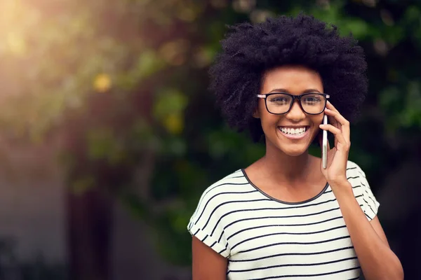 Nennen Sie die Menschen, die Sie glücklich machen. Porträt einer glücklichen jungen Frau, die ihr Handy im Freien benutzt. — Stockfoto