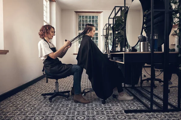 Frisör En konstnär vars verk alltid visas upp. Skjuten av en liten flicka att få håret gjort på salongen. — Stockfoto