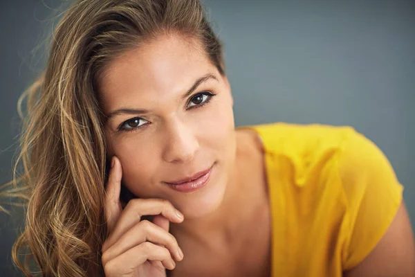 Vertrouwen is stil, onzekerheden zijn luid. Schot van een jonge vrouw poserend tegen een grijze muur. — Stockfoto