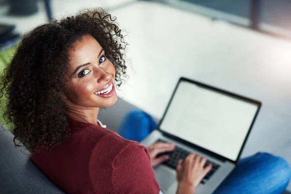 Dit is het blog waar ik aan werk. Portret van een jonge vrouw met behulp van een laptop terwijl ontspannen op de bank thuis. — Stockfoto