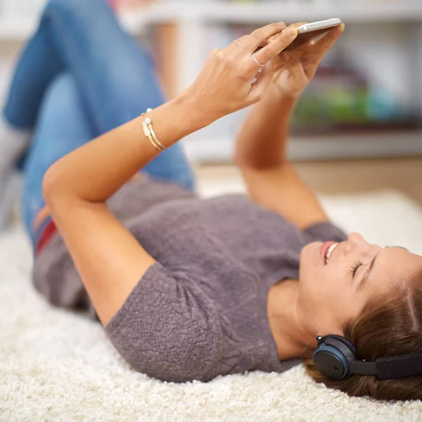 Отдыхает со своими любимыми песнями. Фотография молодой женщины, слушающей музыку во время отдыха дома. — стоковое фото