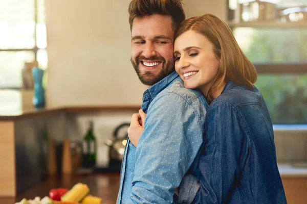 Se ele cozinhar para ti, fica com ele. Tiro de um jovem casal feliz compartilhando um momento carinhoso na cozinha em casa. — Fotografia de Stock