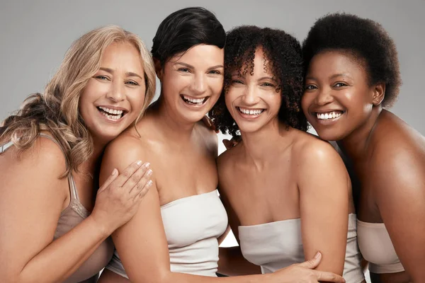 Nunca partilhe os nossos segredos de beleza. Tiro de um grupo diversificado de mulheres de pé e abraçando uns aos outros no estúdio. — Fotografia de Stock