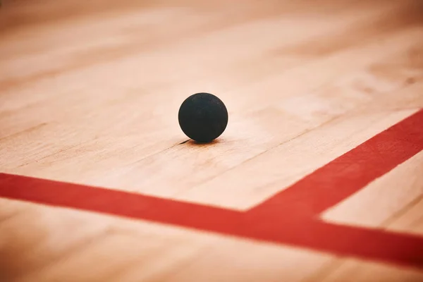 1つの小さなボールに非常に多くのパフォーマンスパワー。スカッシュコートの床にスカッシュボールのショット. — ストック写真