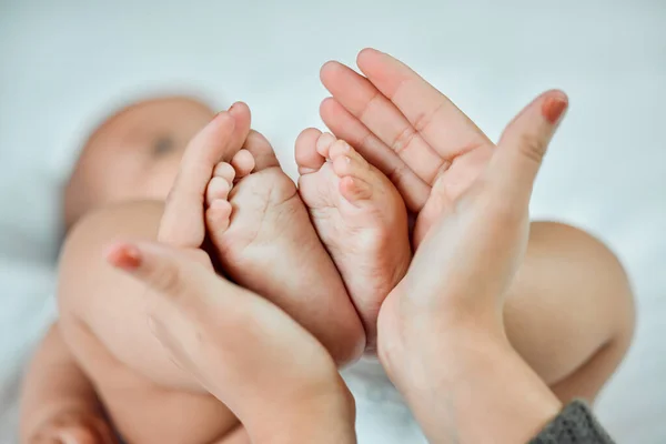 Los pies más pequeños dejan las huellas más grandes en tu corazón. Primer plano de una mujer sosteniendo sus pequeños pies de bebé. — Foto de Stock