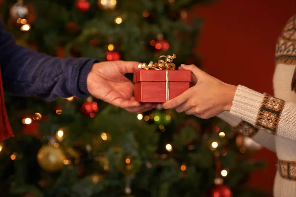 Это традиция кануна Рождества. Обрезанный снимок пары, обменивающейся рождественским подарком. — стоковое фото
