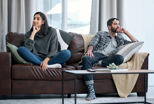 The silent treatment isnt the solution. Shot of a young couple sitting on the sofa and ignoring each other. — Stock Photo, Image