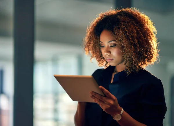 Lavorare in modo intelligente, lavorare sodo. Girato di una giovane donna d'affari che utilizza un tablet digitale durante una tarda notte al lavoro. — Foto Stock