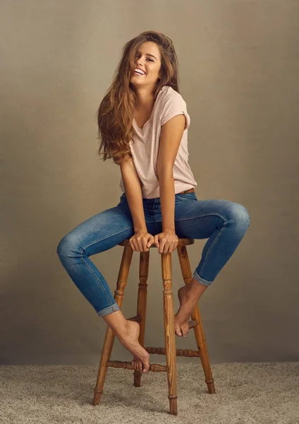 E 'proprio quello che ti serve in una giornata nuvolosa. Studio girato di una bella giovane donna seduta su uno sgabello su uno sfondo semplice. — Foto Stock