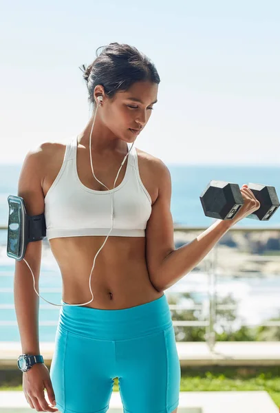 O caminho para o sucesso está coberto de suor. Tiro cortado de uma jovem usando halteres em sua rotina de exercícios. — Fotografia de Stock