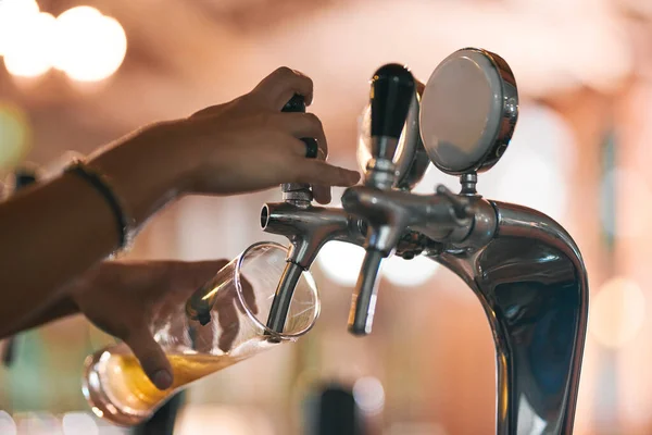 De eerste van de dag uitgieten. Schot van een onherkenbare persoon die overdag een biertje uit een kraan in een bierbrouwerij giet. — Stockfoto