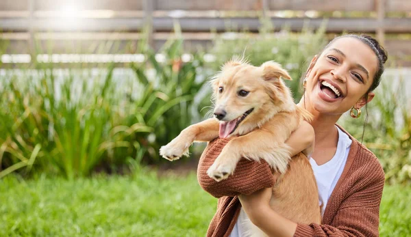 Te presento a mi nuevo instructor de yoga. Retrato de una joven atractiva sosteniendo juguetonamente a su perro en el jardín. — Foto de Stock