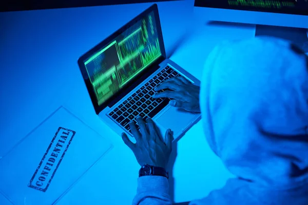 Kau secara resmi telah diretas. Sudut tinggi ditembak seorang hacker laki-laki muda menggunakan laptop dalam gelap. — Stok Foto