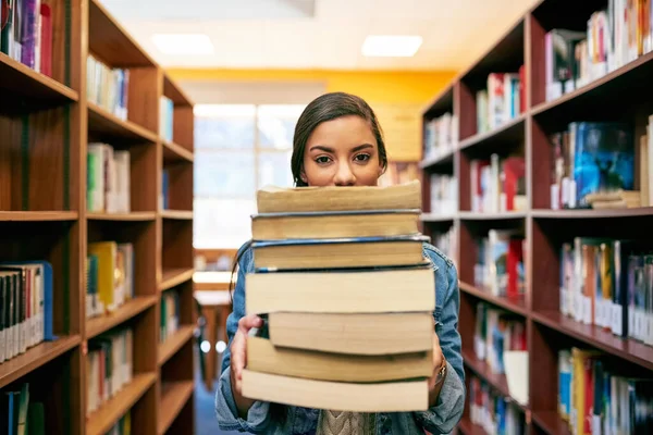 E 'una pila di conoscenza. Ritratto di uno studente universitario che tiene un mucchio di libri nella biblioteca del campus. — Foto Stock