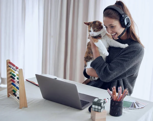 You can never tell where your influence stops. Shot of a young teacher showing her cat to a student online at home.