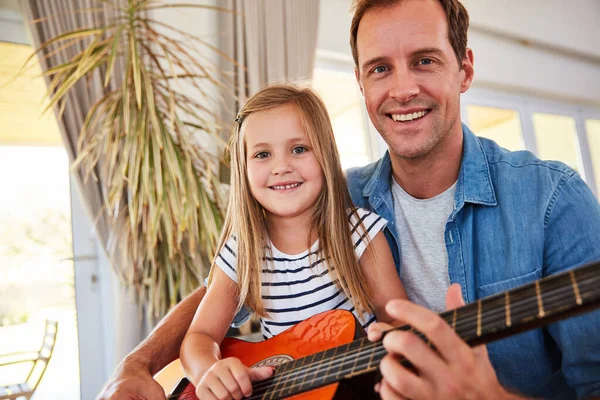 We gaan deze woonkamer laten rocken. Portret van een vader en zijn jonge dochter die samen in de woonkamer thuis gitaar spelen. — Stockfoto