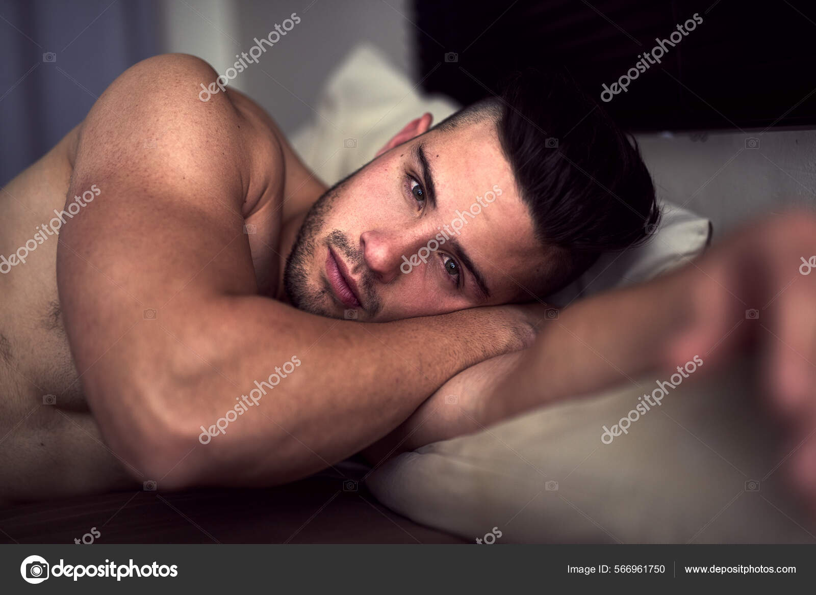 My bed, or yours. Portrait of a shirtless young man giving an inviting look while lying in bed