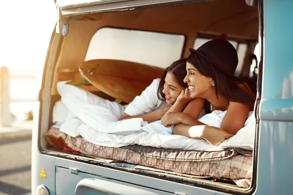 Ovunque sia meglio insieme. Girato di due amici felici rilassarsi su una coperta nel vero del loro furgone in un viaggio in auto. — Foto Stock