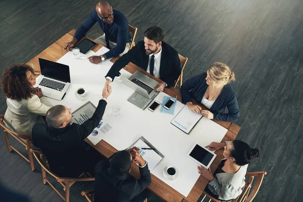 Trabajando en equipo para aumentar la productividad. Foto de alto ángulo de un equipo de empresarios que trabajan alrededor de una mesa en la oficina. —  Fotos de Stock