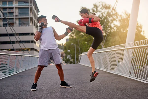 在她的腿上工作拍到一对年轻夫妇在外面的桥上练跆拳道. — 图库照片