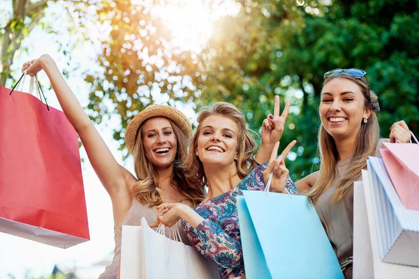On adore faire du shopping. Portrait recadré de trois jeunes copines faisant du shopping dans le centre-ville. — Photo