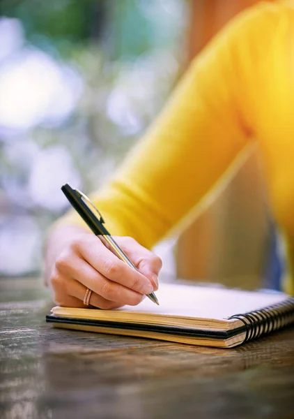 Yaz çünkü düşüncelerinin gidecek bir yere ihtiyacı var. Bir kadının masada oturup not defterine bir şeyler yazması.. — Stok fotoğraf