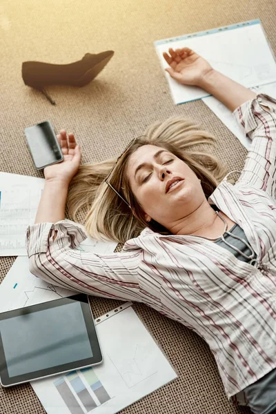 Praca może sprawić, że poczujesz się fizycznie i psychicznie wyczerpany. Duże ujęcie zestresowanej bizneswoman leżącej na podłodze w biurze. — Zdjęcie stockowe