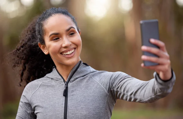 Curta e inscreva-se se quiser mais dicas de fitness. Tiro de uma jovem apta a tirar uma selfie enquanto saía para correr. — Fotografia de Stock
