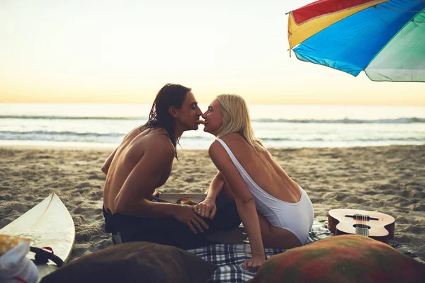 私たち自身の女性とトランプシーンを行いましょう。ピクニックデートをし、日没時にビーチでピザスライスを共有する若い愛情のあるカップルのレビューショット. — ストック写真