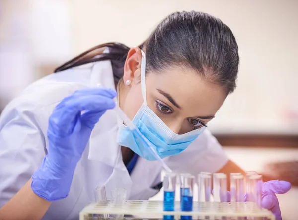 Ela não vai parar até encontrar a cura. Tiro de um jovem cientista que transfere líquido de uma pipeta para um tubo de ensaio num laboratório. — Fotografia de Stock
