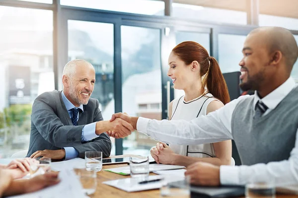 Välkommen till laget. Beskuren bild av två affärsmän som skakar hand under ett möte. — Stockfoto
