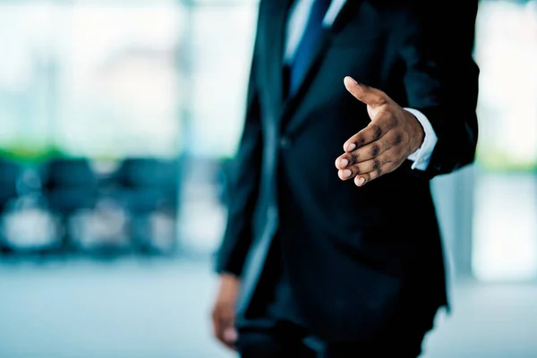 Det är bra att göra affärer med dig. Närbild av en oigenkännlig affärsman sträcker ut handen för ett handslag på kontoret på jobbet under dagen. — Stockfoto