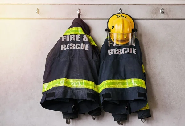 Fogo e salvamento. Tiro cortado de roupas de fogo pendurado em uma parede. — Fotografia de Stock