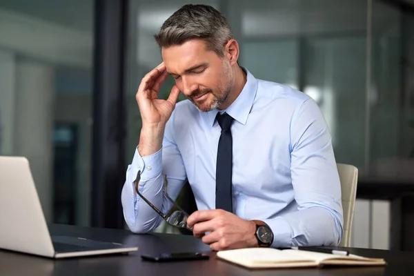 편두통은 정말로 생산성을 떨어뜨린다. 잘 생긴 사업가 가 사무실에 있는 책상에서 일하다가 두통으로 고생하는 장면 이 우연히 찍힌 사진. — 스톡 사진