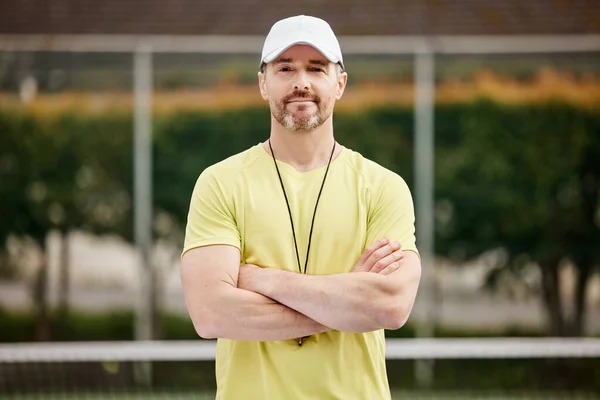 Είναι πολύ σίγουρος προπονητής. Κομμένο πορτραίτο ενός όμορφου ώριμου άνδρα προπονητή τένις που στέκεται με τα χέρια του διπλωμένα στο γήπεδο. — Φωτογραφία Αρχείου