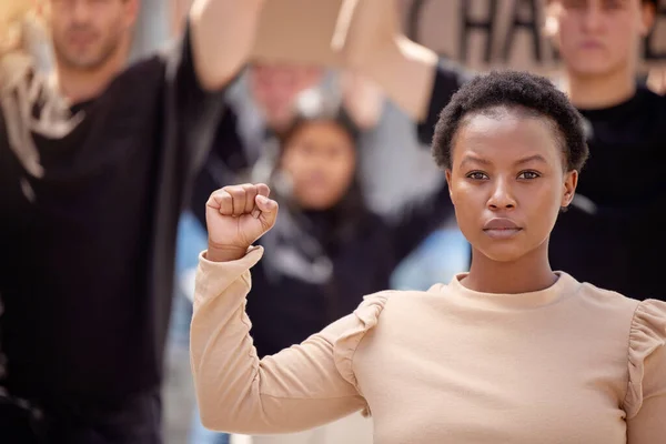 Dédié à la cause. Tourné d'une jeune femme avec son poing levé en solidarité lors d'une marche. — Photo