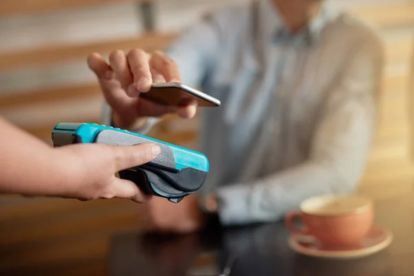 간단하고 똑똑 하고 쉽습니다. 한 남자 가 카페에서 NFC 기술을 이용해 핸드폰으로 돈을 지불하는 모습. — 스톡 사진