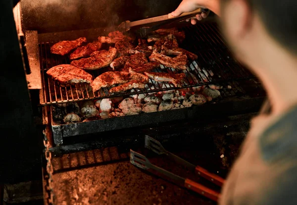 Ruhe bewahren und weiter grillen. Nahaufnahme eines nicht erkennbaren Mannes beim Grillen von Fleisch. — Stockfoto