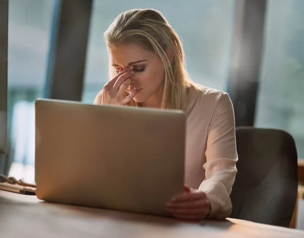 Le stress l'atteint. Tournage d'une jeune femme d'affaires épuisée travaillant sur un ordinateur portable dans un bureau. — Photo