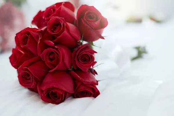 Las rosas son rojas y el amor es para siempre. Tiro de un ramo de rosas rojas tumbadas en una cama. — Foto de Stock